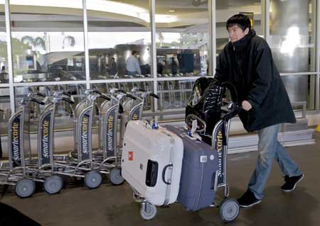 China's star hurdler Liu Xiang arrives at Los Angeles International Airport in the United States to transfer flight to Houston on Dec. 3, 2008. Liu Xiang will undergo surgery in Houston on Friday for his ankle injury that forced him out of the 2008 Beijing Olympics. 