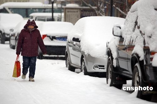 A senior walks slowly along the snow-covered road in Urumchi, capital of northwestern China's Xinjiang Uygur Autonomous Region, on Tuesday, December 3rd, 2008. 
