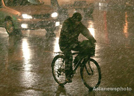 A man makes his way on bicycle in the snow in Shenyang, capital city of Northeast China's Liaoning province, December 3, 2008. Cold air hit most of the northern part of the country from Wednesday with a dramatic drop in temperatures. [Asianewsphoto]