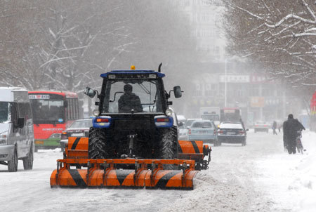 A man drives a snow-clearing vehicle in Qiqihar of Northeast China's Heilongjiang Province, December 3, 2008. Cold air hit most of the northern part of the country from Wednesday with a dramatic drop in temperatures. [Xinhua]