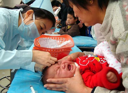 A baby receive anti-flu treatment in Suzhou, Jiangsu province, on Thursday. The number of people suffering from flu has increased sharply as an intense cold front sweeps through most parts of the country. [China Daily] 