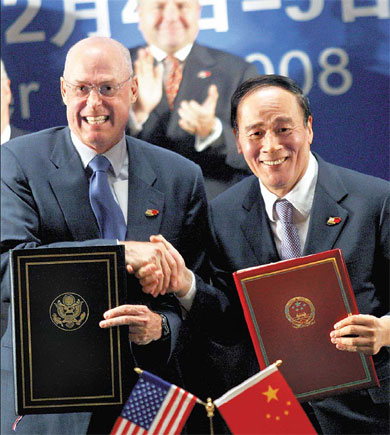 Vice-Premier Wang Qishan and US Treasury Secretary Henry Paulson greet each other at a signing ceremony during the Sino-US Strategic Economic Dialogue in Beijing yesterday. [Yang Shizhong/China Daily]