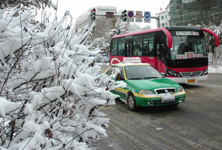 Vehicles travel on the street after a heavy snow in Meihekou, Northeast China's Jilin Province, December 4, 2008. Vast areas from north to central China are experiencing a rare strong cold wave front in recent years, which have forced 26 provinces and municipalities to issue cold weather alerts.[Xinhua]