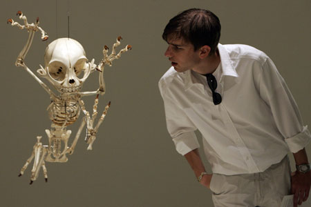 visitor looks at a mock skeleton of the cartoon character Tom of 'Tom and Jerry' by South Korea's artist Hyungkoo Lee during a special exhibition 'Animatus' at Natural History Museum Basel Aug. 26, 2008. [China Daily/Agencies] 