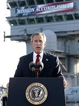 US President George W. Bush addresses the nation aboard the nuclear aircraft carrier USS Abraham Lincoln in 2003. [Stephen Jaffe/File/AFP] 
