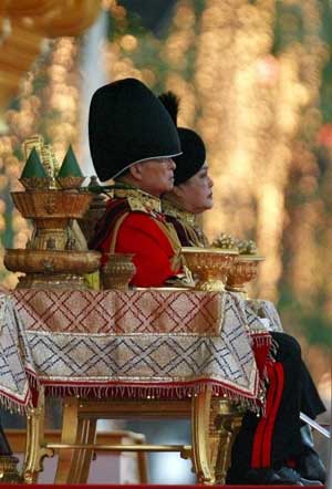 Thailand&apos;s revered King Bhumibol Adulyadej (L) and Queen Sirikit attend the annual Trooping of the Colour military parade in Bangkok&apos;s Royal Plaza Dec. 2, 2008. The Thai King, the world&apos;s longest reigning monarch, will turn 81-years-old on Dec. 5. [Xinhua/Reuters]