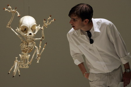 A visitor looks at a mock skeleton of the cartoon character Tom of &apos;Tom and Jerry&apos; by South Korea&apos;s artist Hyungkoo Lee during a special exhibition &apos;Animatus&apos; at Natural History Museum Basel August 26, 2008. RNPS(Reuters News Pictures Service) Images of the Year 2008. [China Daily]