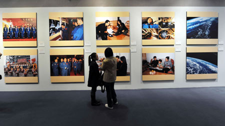 Visitors look at photos on display at the 'China's First Spacewalk Mission' exhibition at the Hong Kong Science Museum on Saturday, December 6, 2008. Three Chinese astronauts opened the exhibition, which gives local citizens a glimpse of their space journey. [Xinhua]