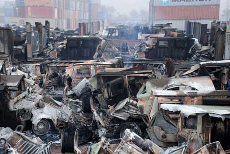 A Pakistani employee looks at burned-out trucks at a NATO terminal outside the northwestern city of Peshawar on Dec. 7.[Xinhua/Reuters]