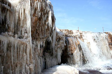 Hukou waterfall is frozen due to temperature dropping, turning its splashing water beads into ice of various shapes - a great attraction to winter tourists. Picture taken on December 7, 2008. [Asianewsphoto via China Daily]