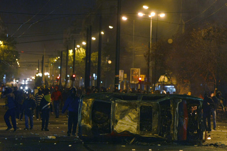 Protesters throw stones against policemen during riots in Athens December 7, 2008. Riots erupted across Greece after police shot dead a teenage boy in the Greek capital, police officials said. [Agencies via China Daily] 