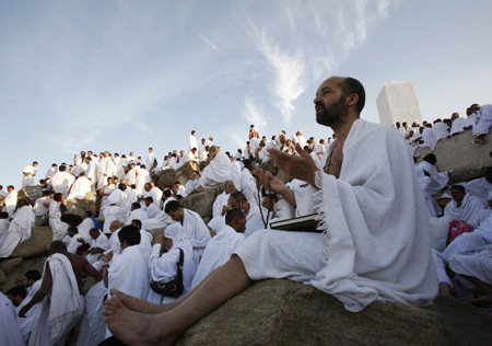 A Muslim pilgrim prays on Mount Mercy on the plains of Arafat outside the holy city of Mecca December 7, 2008. More than two million Muslims began the haj pilgrimage on Saturday, heading to a tent camp outside Mecca to follow the route Prophet Mohammad took 14 centuries ago. [Agencies via China Daily] 