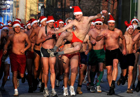 Santa Clause in swimming suits and Christmas hats participate in a race in Budapest, Hungary, Dec. 7, 2008. Starting from a skating rink in Westend City Center, people sang Christmas carol and ran to the Oktogon, which is hundreds meters away. The race is held to collect money for a children's hospital.[Xinhua]
