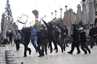 Protesters throw objects towards riot police during clashes in the northern port city of Thessaloniki, Greece, on Sunday, Dec. 7, 2008. [Nikolas Giakoumidis/AP Photo] 