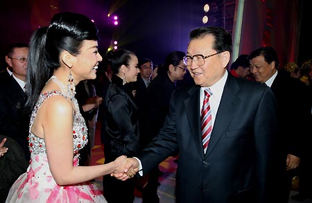 Li Changchun (front, R), a member of the Standing Committee of the Political Bureau of the Communist Party of China (CPC) Central Committee, shakes hands with performers after a concert in Beijing, capital of China, Dec. 6, 2008. Li attended on Saturday night a publishing showpiece exhibition and a concert in celebration of 30 years' reform and opening-up. [Yao Dawei/Xinhua]