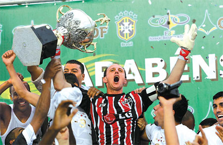 Sao Paulo goalkeeper Rogerio Ceni holds the trophy after defeating Goias to win the team's sixth Brazilian championship title at Bezarrao stadium in Brasilia on Sunday. [Reuters]