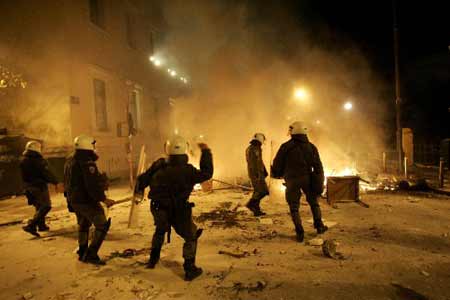 Riot policemen throw stones towards protesters outside of the main Administrative building of Athens&apos; University, December 8, 2008. [Xinhua/Reuters]