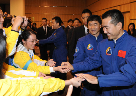  Chinese taikonaut Zhai Zhigang gives souvenir to students during a seminar on the Shenzhou VII manned space mission in China's Macao Special Administrative Region (SAR) Dec. 8, 2008. A delegation of the Shenzhou VII including three taikonauts of the Shenzhou VII space mission Zhai Zhigang, Liu Boming and Jing Haipeng kicked off a three-day visit to Macao on monday. [Xinhua]