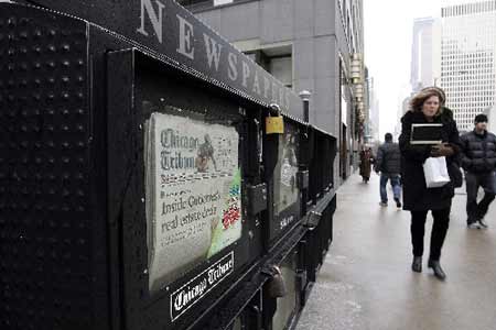 People walk past a newspaper box across from the Chicago Tribune tower in Chicago, Illinois December 8, 2008. [Xinhua/Reuters]