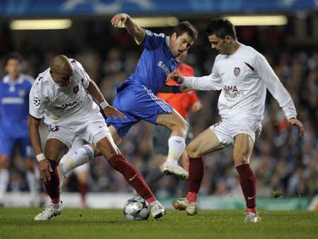 Chelsea's Joe Cole (C) is tackled by CFR Cluj's Alvaro Pereira (L) and Cadu during their Champions League soccer match at Stamford Bridge in London December 9, 2008. [Xinhua/Reuters]