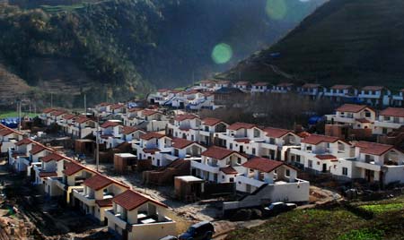 Photo dated on Dec. 8, 2008 shows the relocated Quanli village in Lueyang county, northwest China's Shaanxi Province. Two hundred and six quake-survived villagers have moved into their new houses in the newly-built village prior to the upcoming winter.(Xinhua Photo)