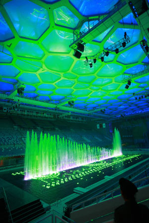 Lights of a music fountain are reflected on the ceiling of the National Aquatic Center, also known as the Water Cube in Beijing, capital of China, Dec. 8, 2008. [Li Mingfang/Xinhua]