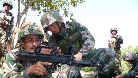 An Indian soldier tries Chinese weapons during a training session of the 'Hand in Hand 2008' China-India army joint anti-terrorism training in Belgaum of India, Dec. 9, 2008. [Li Gang/Xinhua] 