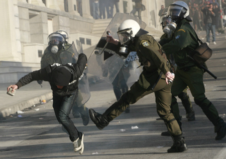 A protester tries to escape from riot policemen during a demonstration in Athens December 9, 2008. Hundreds of protesters threw stones and bottles at lines of riot police outside the Greek parliament on Tuesday, in a fourth day of anti-government clashes triggered by police killing a teenager.[Agencies via China Daily]