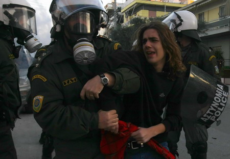 Police detain a youth during riots following the funeral of Alexandros Grigoropoulos at Athens' suburb of Nea Smyrni December 9, 2008. Riot police fought running battles with hundreds of protestors outside Greece's parliament on Tuesday while the opposition socialist party called for elections to end four days of protests. [Agencies via China Daily]