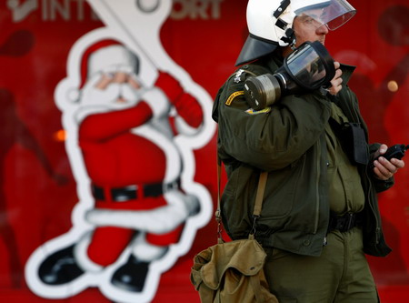 A riot police officer speaks on the radio in Athens December 9, 2008. Riot police fought running battles with hundreds of protestors outside Greece's parliament on Tuesday while the opposition socialist party called for elections to end four days of protests. [Agencies via China Daily]