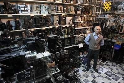 Camera collector Dimitris Pistiolas poses inside his basement museum, with the walls covered in movie cameras and projectors on Friday, Oct. 24, 2008. The museum is the largest of its kind in the world. Pistiolas owns the world's largest private collection of movie cameras — 937 vintage models and projectors.