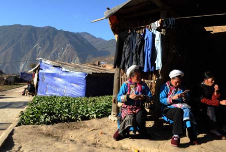 Qiang ethnic women chat and embroider insoles in Luobozhai Village of Yanmen Township, the quake-hit Wenchuan County, southwest China's Sichuan Province, Dec. 8, 2008.