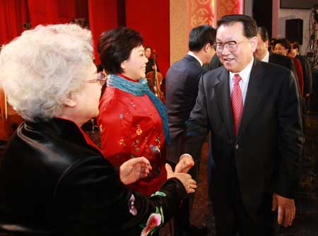 Li Changchun (1st R), member of the Standing Committee of the Political Bureau of the Communist Party of China (CPC) Central Committee, shakes hands with artists after a concert celebrating 30 years' reform and opening-up in Beijing Dec. 10, 2008.