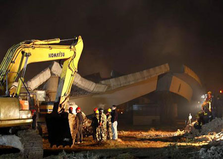 Rescuers and an excavator gather at the collapsed bridge, preparing for the rescue operation early Wednesday, December 10, 2008. Two people were killed and four others injured when a 200-meter section of a bridge that was undergoing demolition collapsed in Kunming, Yunnan province Tuesday evening. [Xinhua]