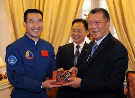 Macao Special Administration Region (SAR) Chief Executive Ho Hau Wah(R) presents astronaut Zhai Zhigang with an album of their photos in Macao during a farewell ceremony in Macao Dec. 10, 2008. [Xinhua]