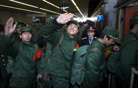  Recruit for the People's Liberation Army get aboard the train before heading off to start their service, at a train station in Tianjin, December 10, 2008. [Xinhua]