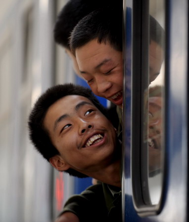  Recruit for the People's Liberation Army wait for the train to start before leaving to start their service, at a train station in Lanzhou, Northwest China's Gansu Province, December 10, 2008. [Xinhua]