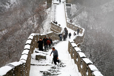 People walk along a snow-covered section of the Great Wall in Beijing Wednesday. [China Daily] 