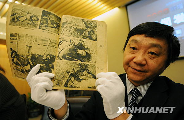 Zhu Chengshan, curator of the Memorial Hall of the Victims of the Nanjing Massacre shows a piece of evidence from the Nanjing Massacre and other Japanese atrocities during WWII, in Nanjing, east China's Jiangsu Province, on Dec. 11, 2008. The 816 pieces of new evidence, including documents, videos, books, calligraphy and paintings, were collected this year mainly from China, the United States and Japan. (Xinhua Photo)
