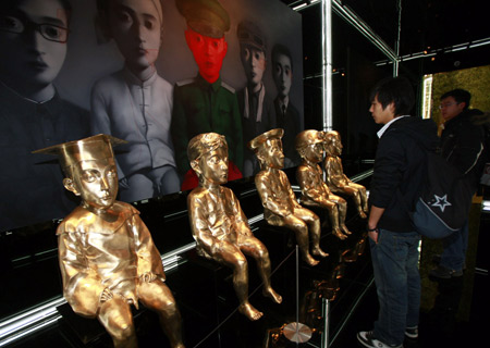 Visitors look at works of Chinese artist Zhang Xiaogang during an exibition held at the Ullens Center for Contemporary Art at the 798 Art Zone in Beijing, China, Dec. 10, 2008. The exhibition, 'Christian Dior and Chinese Artists', featured over 100 Dior Couture pieces from Paris and works of 20 contemporary Chinese artists. The show symbolizes an open dialogue between two different means of expression, contemporary art and fashion. [Xinhua]