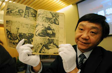 Zhu Chengshan, curator of the Memorial Hall of the Victims of the Nanjing Massacre shows a piece of evidence from the Nanjing Massacre and other Japanese atrocities during WWII, in Nanjing, east China's Jiangsu Province, on Dec. 11, 2008. The 816 pieces of new evidence, including documents, videos, books, calligraphy and paintings, were collected this year mainly from China, the United States and Japan. [Xinhua]