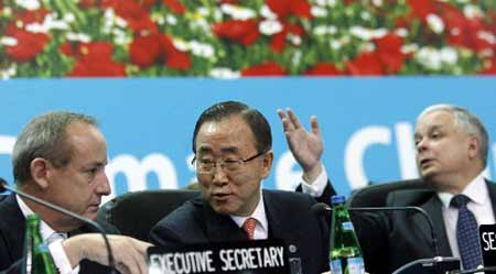 UN Secretary-General Ban Ki-moon (C) speaks to UNFCCC Executive Secretary Yvo de Boer as Polish President Lech Kaczynski (R) gestures during the UN climate change conference in Poznan December 11, 2008.