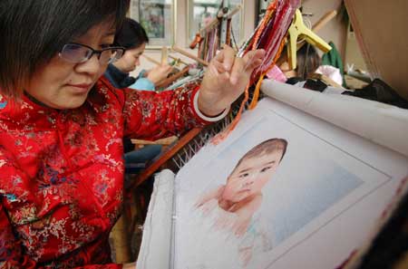 Handicrafts woman Pu Fengjuan gives the final touch to a piece of embroidery in Suzhou city, east China's Jiangsu Province, Dec. 11, 2008.