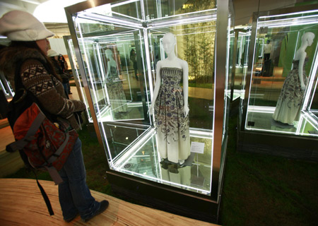 A visitor looks at a dress designed by Christian Dior, an influential French fashion designer, during an exibition held at the Ullens Center for Contemporary Art at the 798 Art Zone in Beijing, capital of China, Dec. 10, 2008.