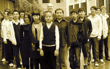 Shanghai International Youth Orchestra founder Sam Matthews poses with the orchestra members.