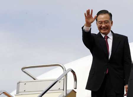 Chinese Premier Wen Jiabao waves upon his arrival for a trilateral meeting between leaders of China, Japan and South Korea at the airport of Fukuoka, Japan, Dec. 13, 2008. (Xinhua Photo)