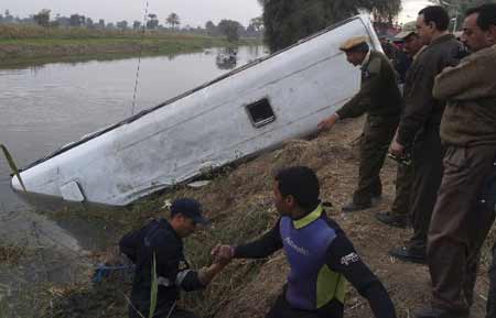 Policemen stand next to the wreckage of a bus in El Minya, about 150 km (93 miles) southwest of Cairo, December 14, 2008. 