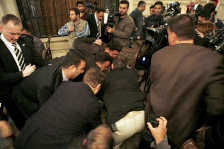 Security personnel tackle a man who threw a shoe at U.S. President George W. Bush during a joint statement with Iraqi Prime Minister Nouri al-Maliki in Baghdad, December 14, 2008. 