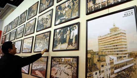 A man stands before the old photos of an exhibition featuring China's 30 years' reform and opening-up in southwest China's Chongqing Municipality Dec. 14, 2008. 