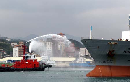 A freight ship leaving for the Chinese mainland receives blessings by being sprayed water at a ceremony marking the start of direct sea transport between the Chinese mainland and Taiwan at Keelung Harbor of southeast China's Taiwan, Dec. 15, 2008. The Chinese mainland and Taiwan started direct air and sea transport and postal service Monday morning. 